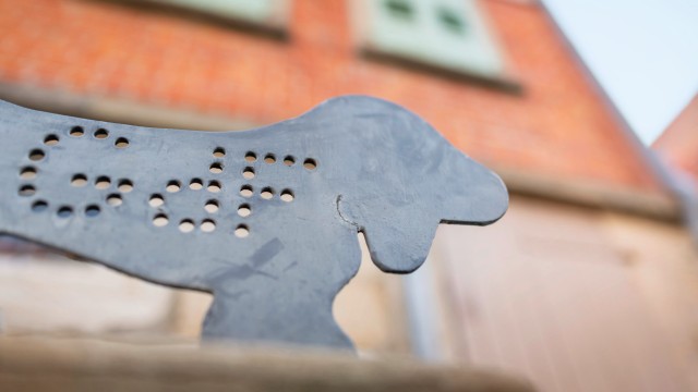 Foto eines Fußabstreifers aus Metall in Form eines Hundes mit Lochausstanzungen und dem Kürzel GdF